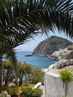 Beautiful view of blue water framed by green trees and stonework.