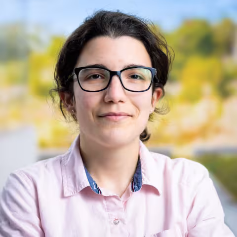 Headshot of Afroditi Papadopoulou wearing pink collared shirt and glasses